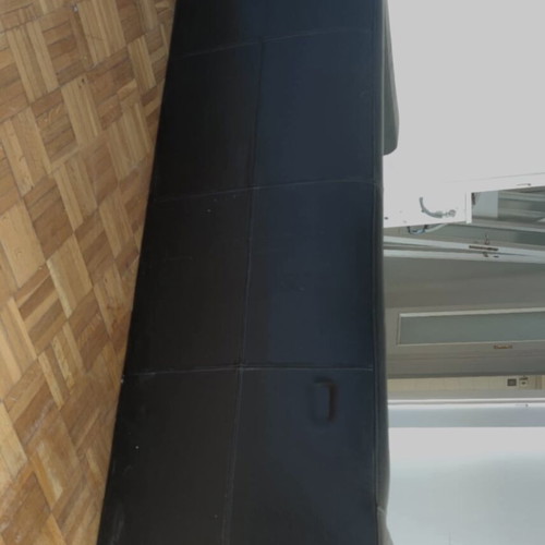 Black leather three-seater sofa used with coffee tables
