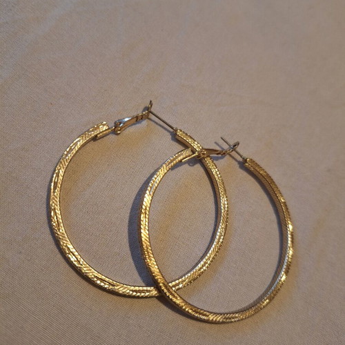Large gold hoop earrings used with embossed texture