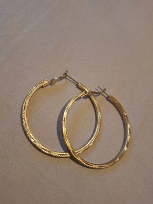 Large gold hoop earrings used with embossed texture