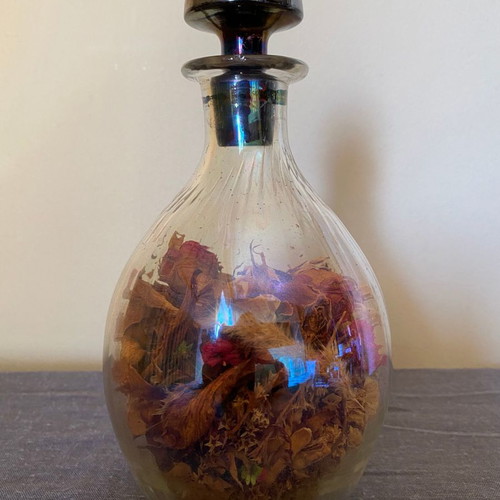 Vintage glass bottle with metal stopper and dried flowers used