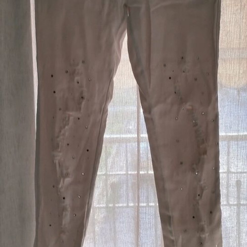 White fitted leggings-style pants with rips and rhinestones used, size S