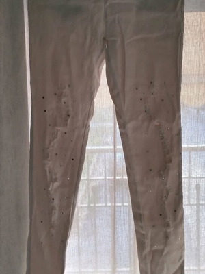 White fitted leggings-style pants with rips and rhinestones used, size S