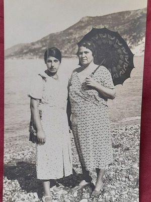 Vintage black and white photo of two women on beach with parasol used