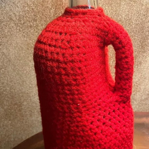Whisky bottle used with handmade red knitted cover