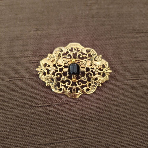Vintage brooch with intricate filigree design and black stone like new