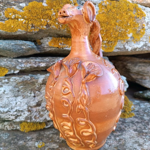 Handmade ceramic jug used with animal-shaped neck and embossed floral designs