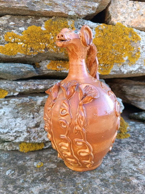 Handmade ceramic jug used with animal-shaped neck and embossed floral designs