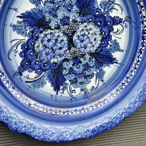 Handmade ceramic wall plate used with blue floral motif