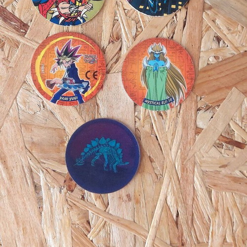 Set of 5 vintage collectible pogs from Spiderman, Yu Gi Oh and dinosaur collections