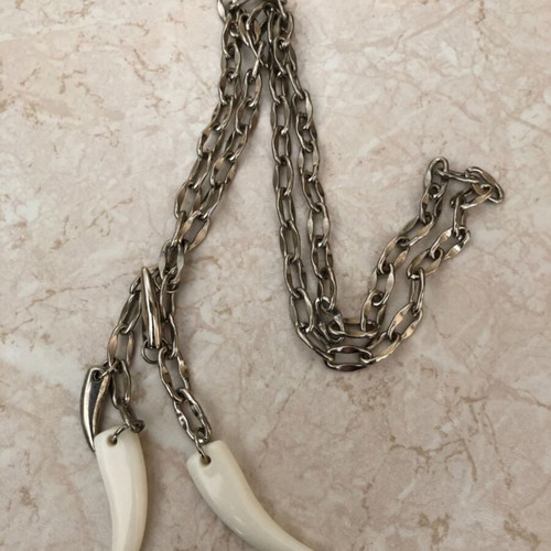 Necklace with plastic and metal fangs