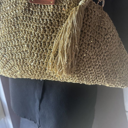 Handmade knitted shoulder bag in gold with decorative tassel