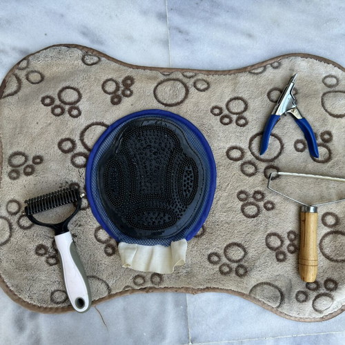 Pet grooming set with mat, glove brush, comb brushes and nail clipper