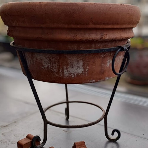 Large terracotta pot with metal stand and clay wedges, used