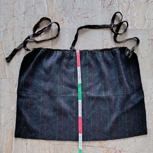 Traditional black apron with vertical stripes used