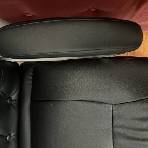 Office chair with black faux leather upholstery and button-tufted back