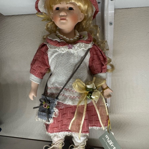 Porcelain doll new with tag and base