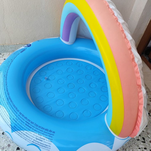 Blue children's pool with canopy used, rainbow design