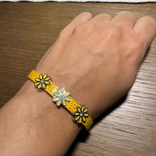 Bracelet with yellow leather strap like new with three metal charms
