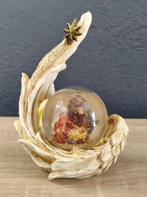 Christmas decorative snow globe featuring the Nativity and a base shaped like an angel's wing
