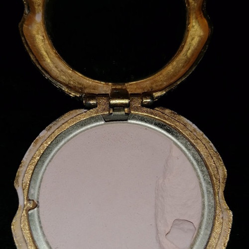 Vintage powder compact used with mirror and gold-plated box with emerald