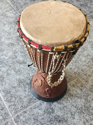 Wooden African drum with carved details and leather membrane