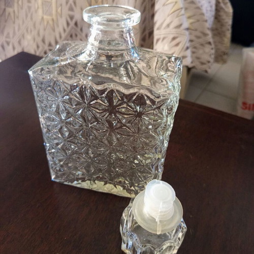 Vintage glass decanter with embossed geometric design and stopper