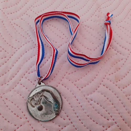 Silver-colored basketball game medal