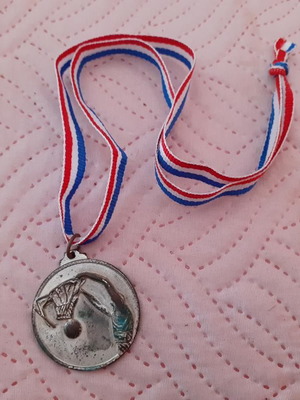 Silver-colored basketball game medal