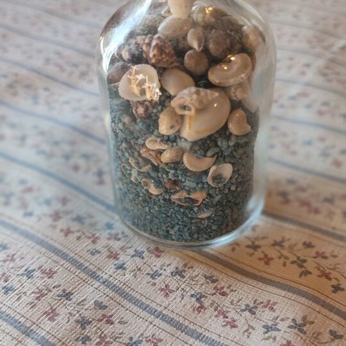 Glass bottle like new with shells and colorful sand