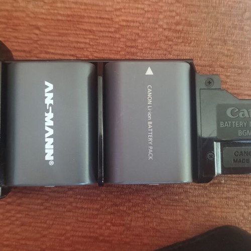 Canon EOS 400D camera used with grip, charger, and two batteries