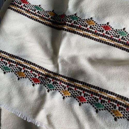 Woven fabric on loom new, thin cream wool textile with embroidery