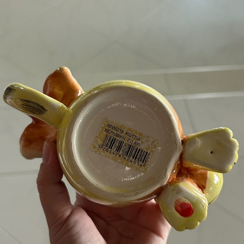 Vintage ceramic mug with embossed monkey design, used