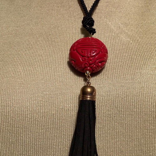 Long pendant like new with red carved bead and black fabric cord