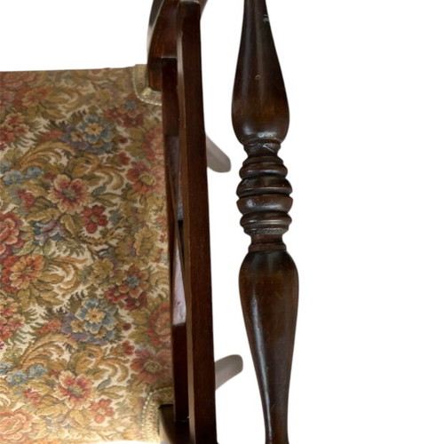 Wooden stool with carved high arms