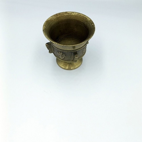 Metal mortar used with face and plant decoration