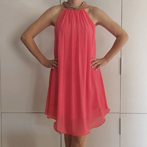 Coral dress with a jewel tie at the neck
