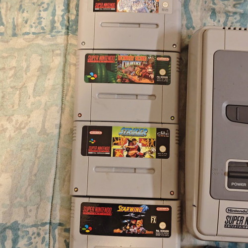 Super Nintendo Entertainment System (SNES) console with 4 games