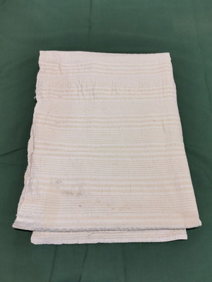 Woven bed sheet used with signs of wear