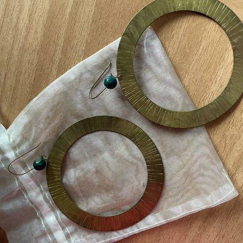 Handmade earrings used, round flat with green bead decoration
