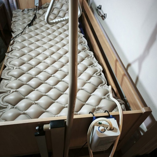 Electric hospital bed with wooden frame, pressure relief mattress and pump
