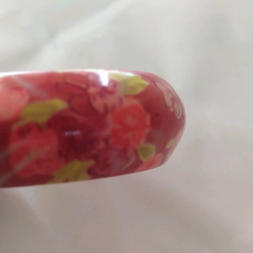 Bracelet asymmetric with pink flowers and green leaves on red background