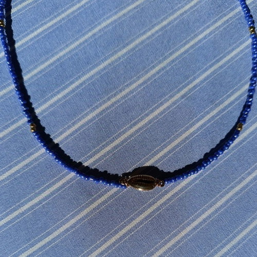 Necklace new made of steel wire with blue and gold glass beads and gold-plated shell