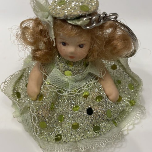 Porcelain doll keychain like new, green, 7cm with movable arms and legs