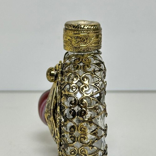Vintage perfume flacon with filigree metalwork and red cabochon