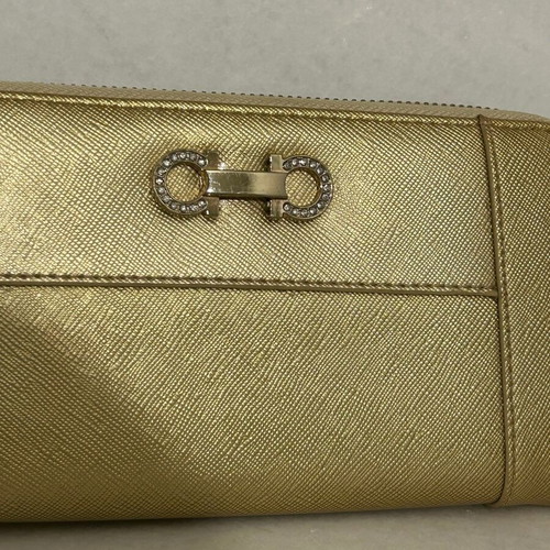 Two gold wallets, one with wrist strap