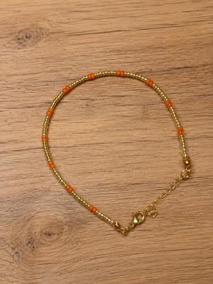Handmade bracelet with gold and red details