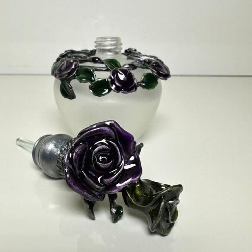 Vintage ornate perfume bottle with frosted glass and metal floral decoration