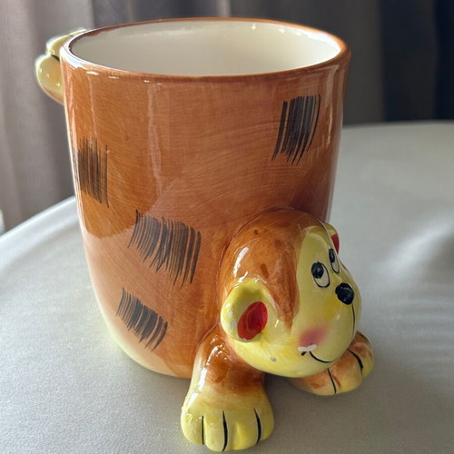 Vintage ceramic mug with embossed monkey design, used