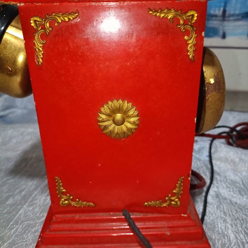 Vintage metal rotary phone, red with gold details