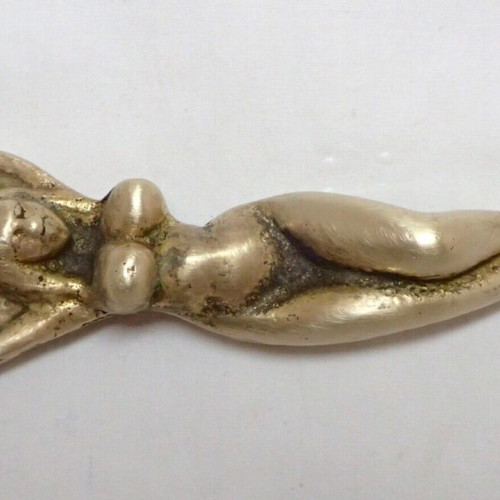 Vintage brass bottle opener shaped like a woman used